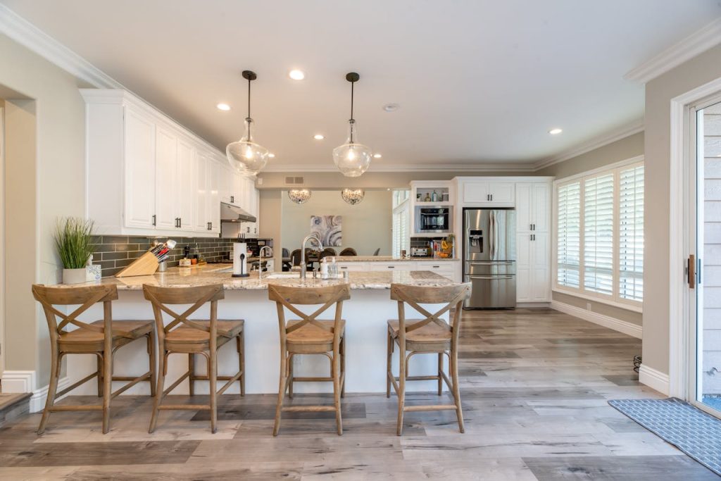 four-brown-wooden-chairs-2635038 Bright and spacious kitchen interior featuring bar stools and modern design elements.